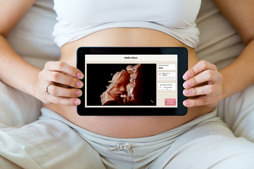 Pregnant woman holding ultrasound scan on her tummy.